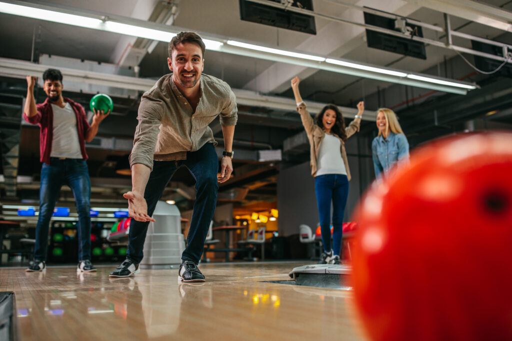 Man bowling with friends supporting him