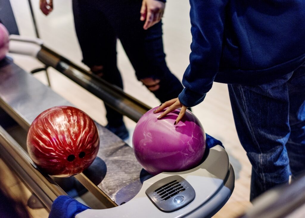 girl picking a bowling ball at Stars and Strikes