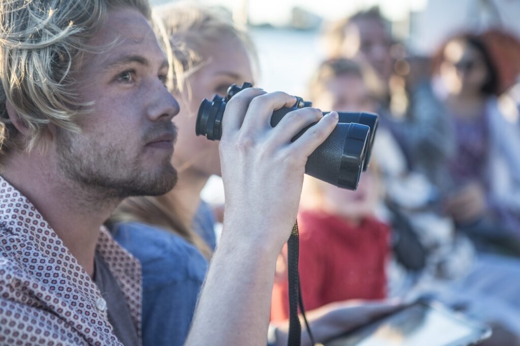 young tourist with binoculars on a ghost tour